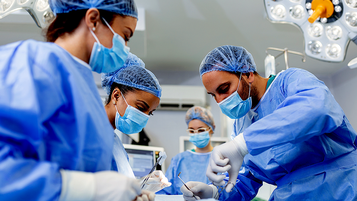 Group of surgeons in operating room with surgery equipment.