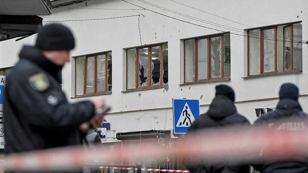 Police officers guard a cordoned-off downtown street following deadly blasts in Lviv.