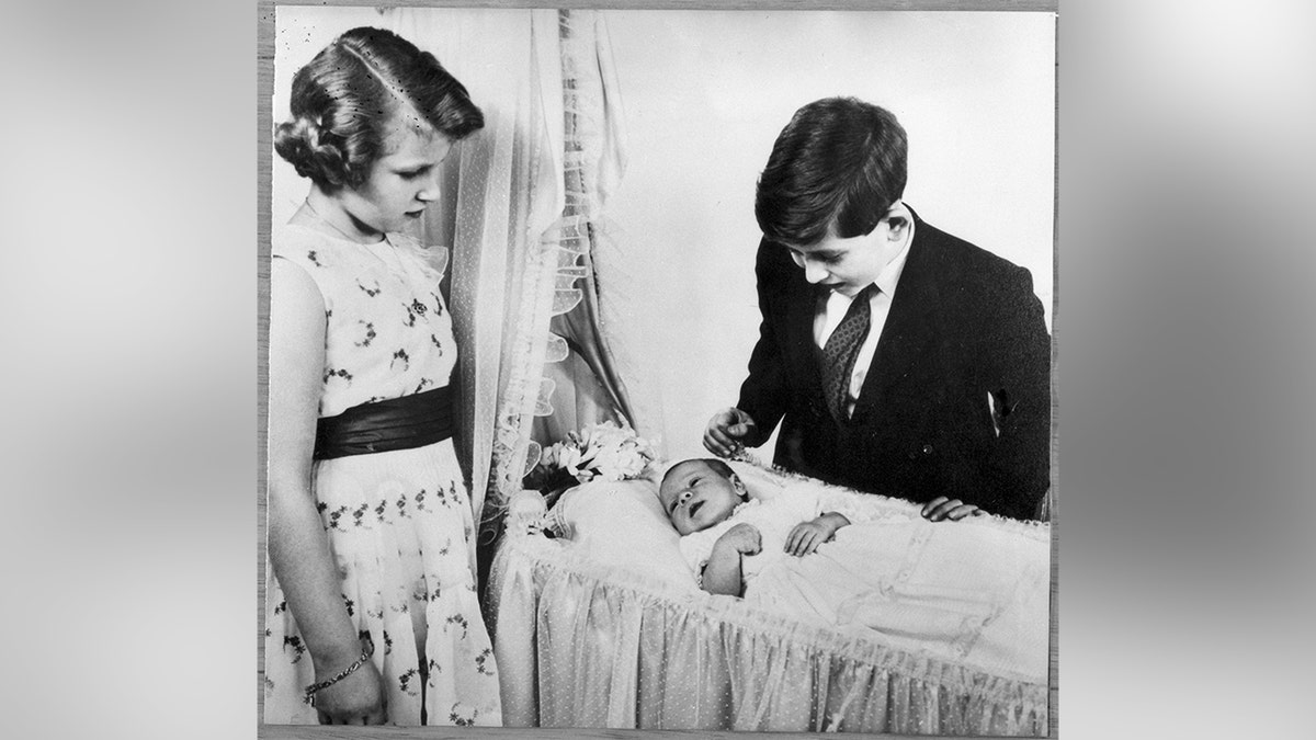 Princess Anne and Prince Charles meeting their younger brother, Prince Andrew in 1960.