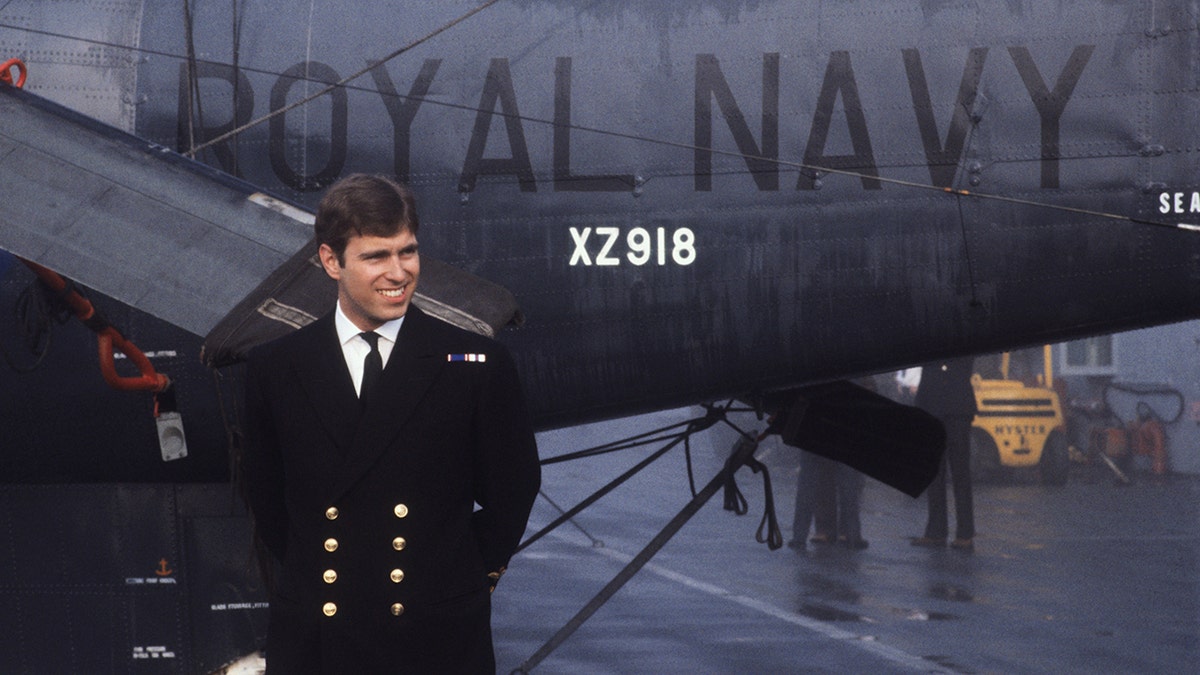 Andrew posing with the helicopter he piloted during the Falklands War.