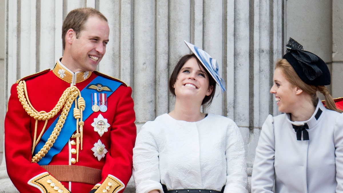 Prince William grinning at his smiling cousins on the balcony of Buckingham Palace.