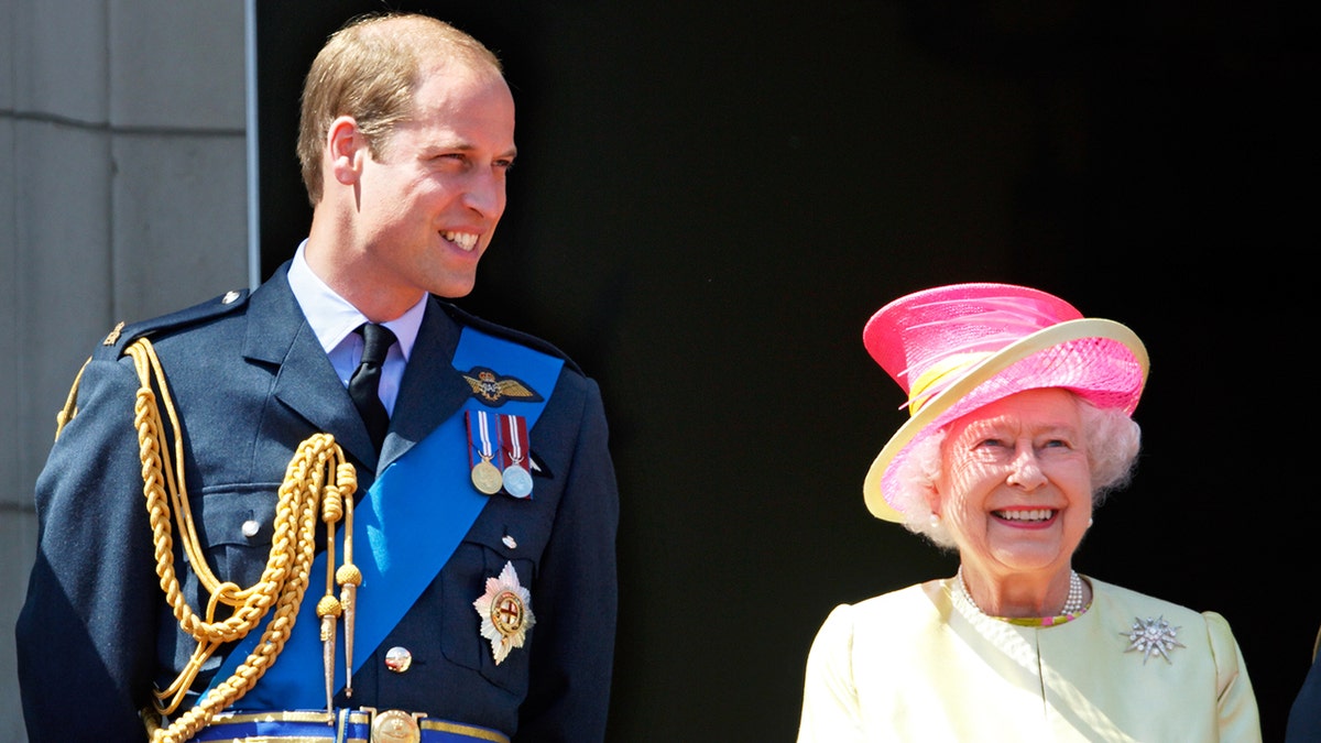 Prince William and Queen Elizabeth smiling on the balcony of Buckingham Palace.