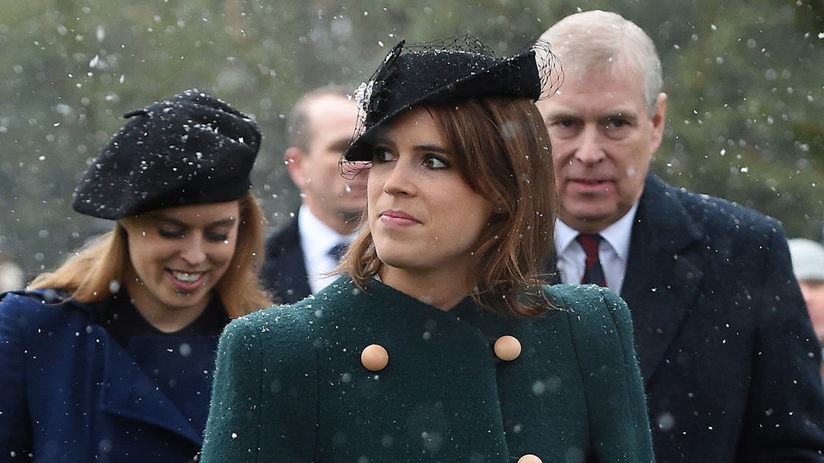 A close-up of Princess Eugenie walking in the snow ahead of her sister Princess Beatrice and father ex-Prince Andrew.