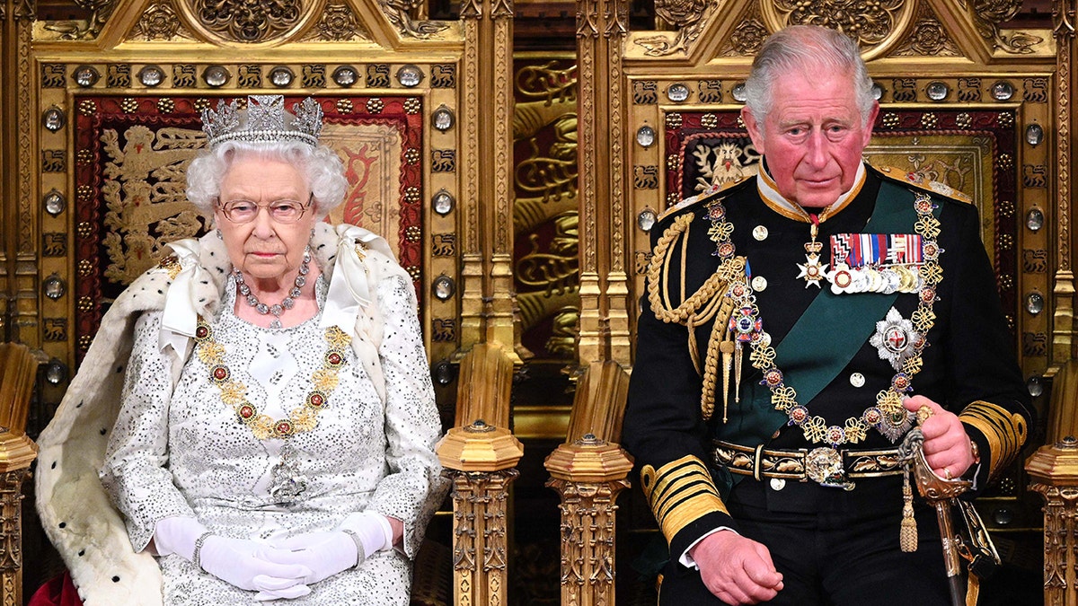 Queen Elizabeth and the former Prince Charles sitting side-by-side in royal regalia on gold thrones.