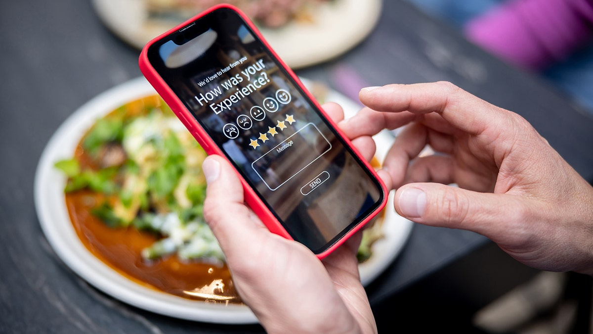 Close-up on a man rating his experience at a restaurant using an app on a cell phone - technology concepts