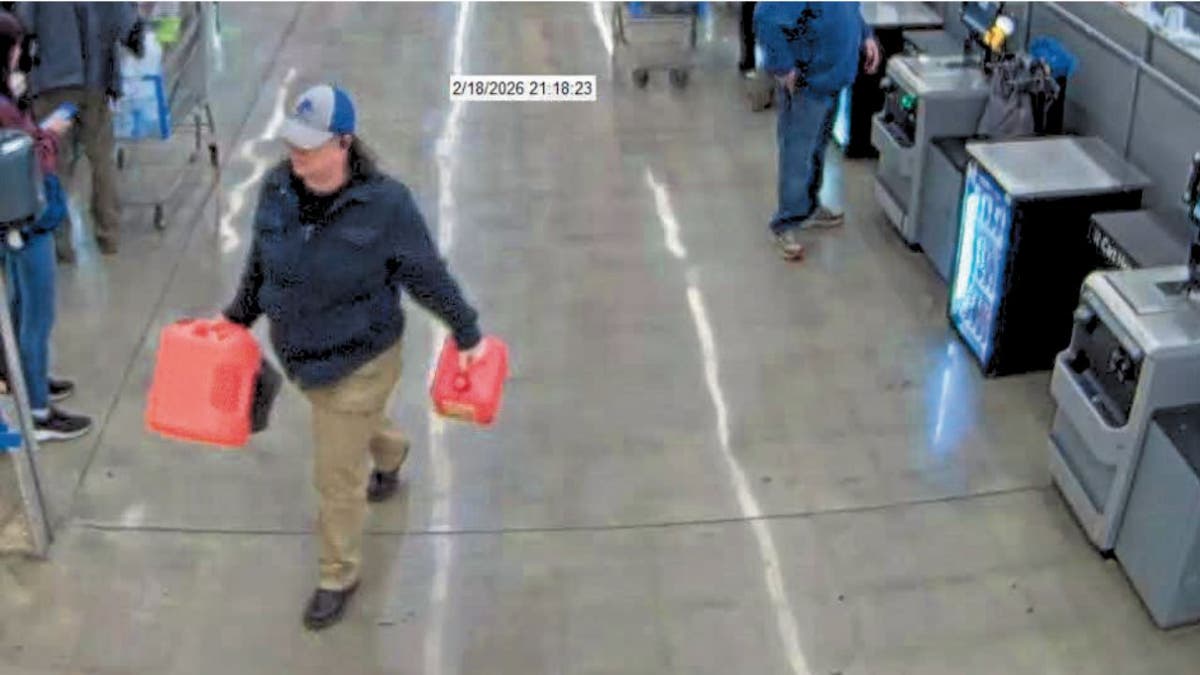 Woman carrying two red gas cans inside a Walmart store captured on surveillance video.