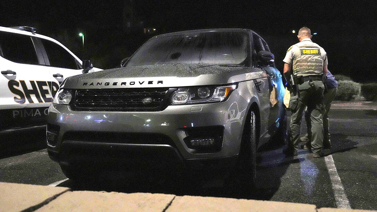 Pima County sheriff and FBI agents check a gray Range Rover in the Culver's parking lot in Tucson