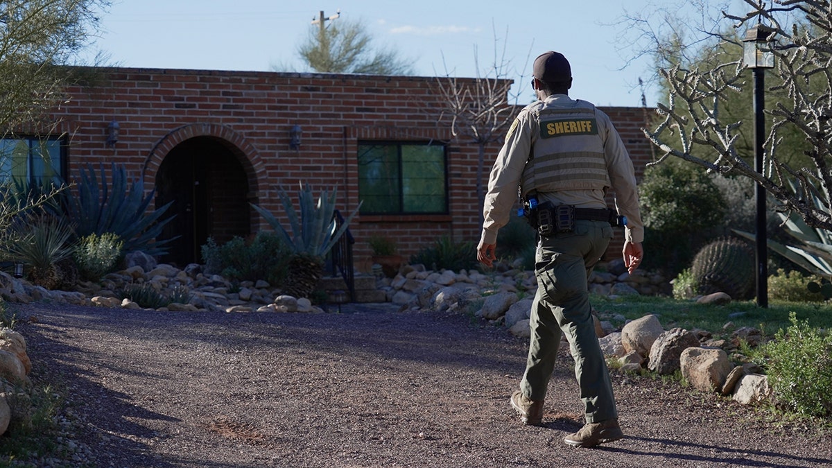 A Pima County sheriff’s officer standing outside a residential home in Tucson, Arizona.