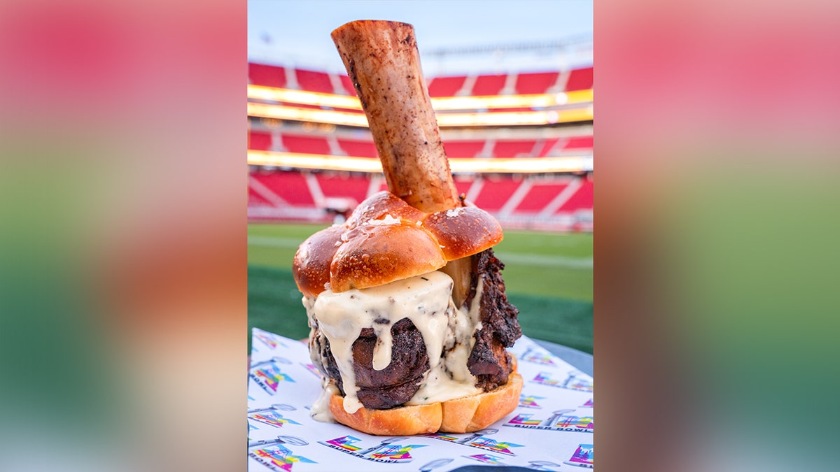LX Hammer Burger: A shareable spin on a cheeseburger with braised bone-in beef shank, roasted mirepoix demi-glace and Point Reyes bleu cheese fondue on a house-based brioche bun, seen at Levi's Stadium in San Francisco ahead of Super Bowl LX.