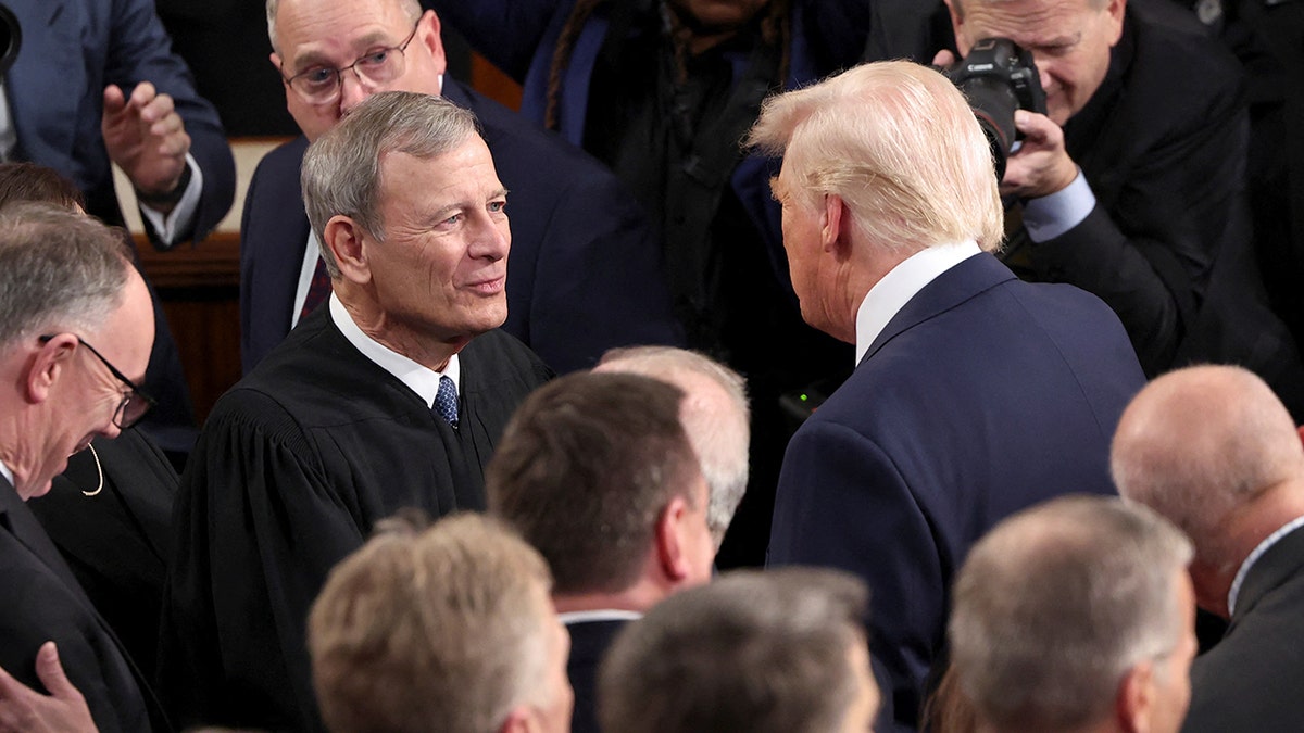 Supreme Court Chief Justice John Roberts shakes President Trump's hand