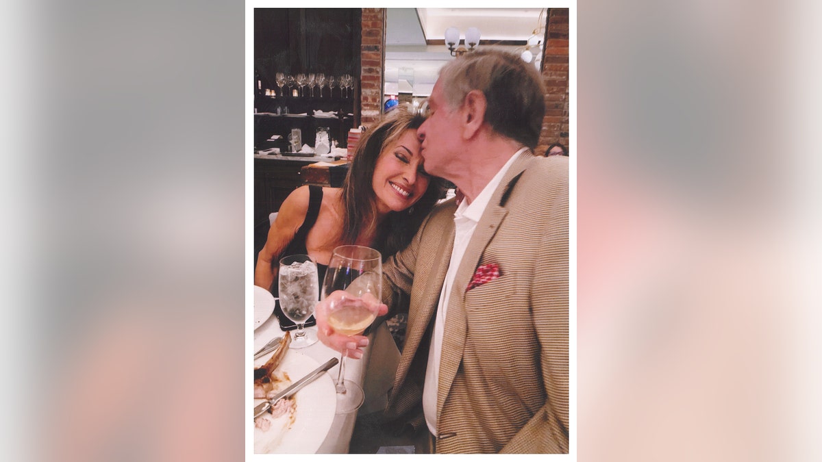 Helmut Huber kissing a smiling Susan Lucci on her forehead.