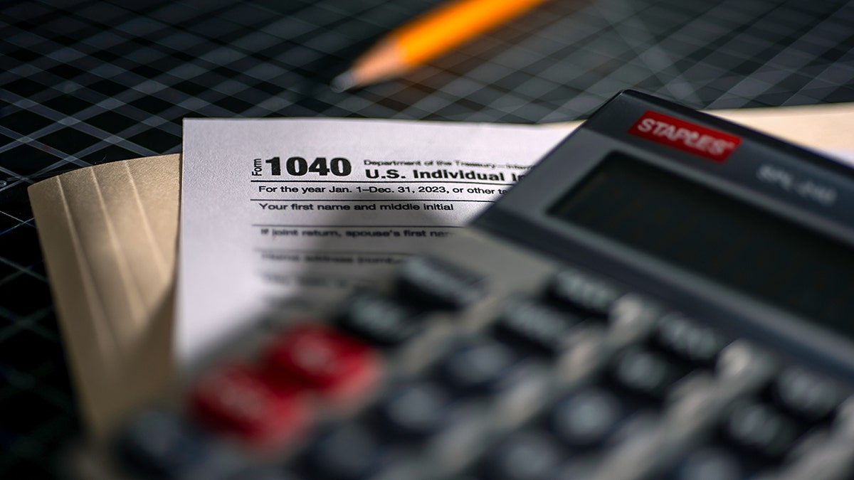 Tax forms and calculator on desk.