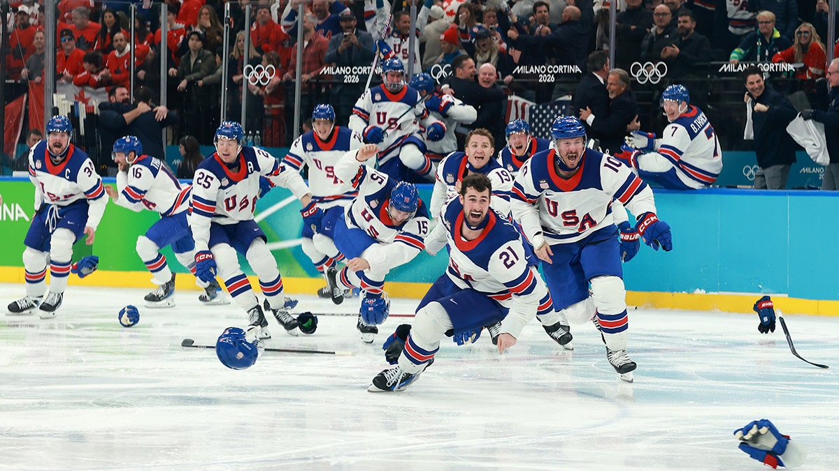 Team USA hockey players celebrating victory on ice rink.