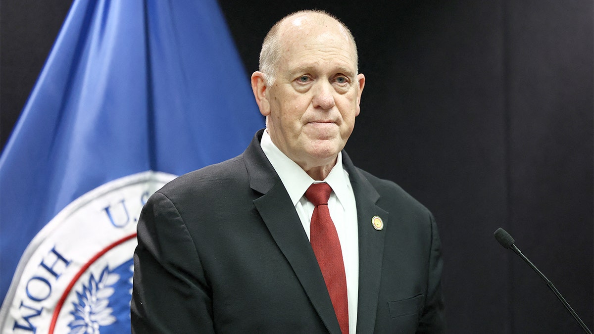 Tom Homan speaks at a podium during a press conference.