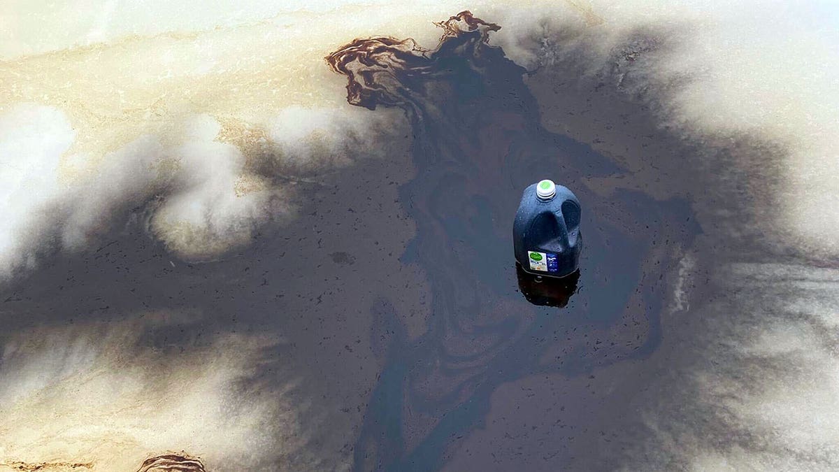 Gallon container sitting in dark liquid on outdoor ice rink