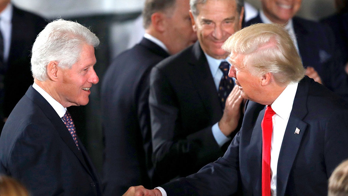 Presidents Clinton and Trump shake hands