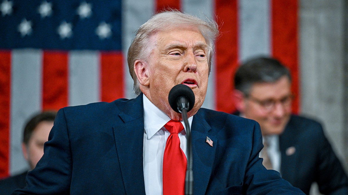 Donald Trump speaking at a podium in front of an American flag during the State of the Union address.