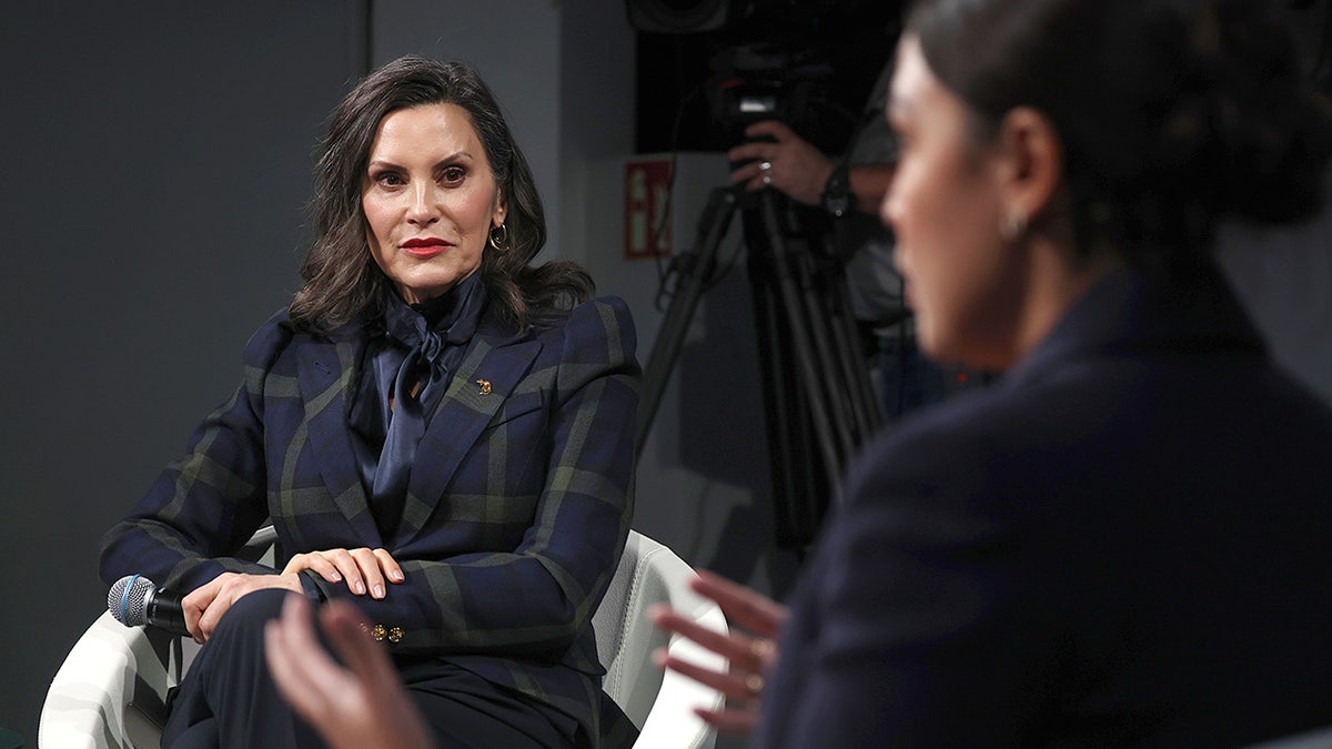 Gretchen Whitmer ascolta Alexandria Ocasio-Cortez parlare alla conferenza di Monaco.