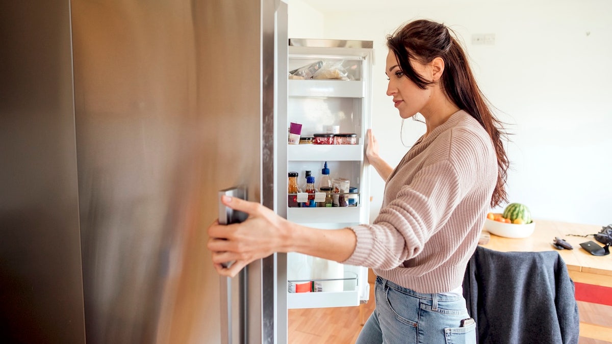Woman looking for food in refrigerator