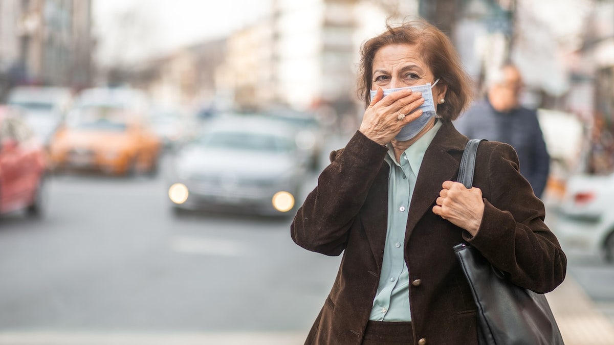 Donna sulla strada della città che indossa una maschera