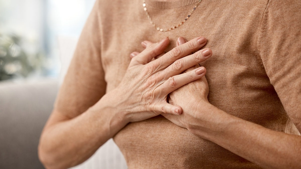 Woman holding her chest - chest pain