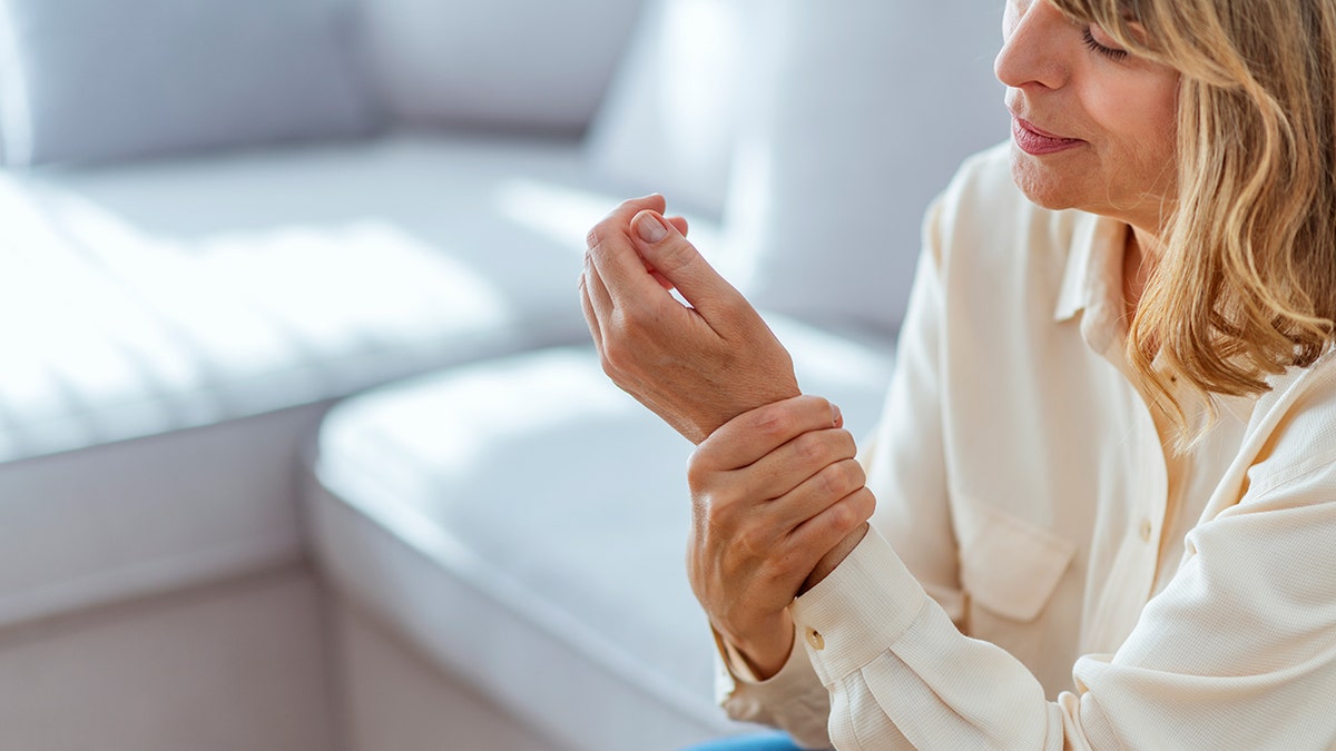 senior woman holds wrist in pain