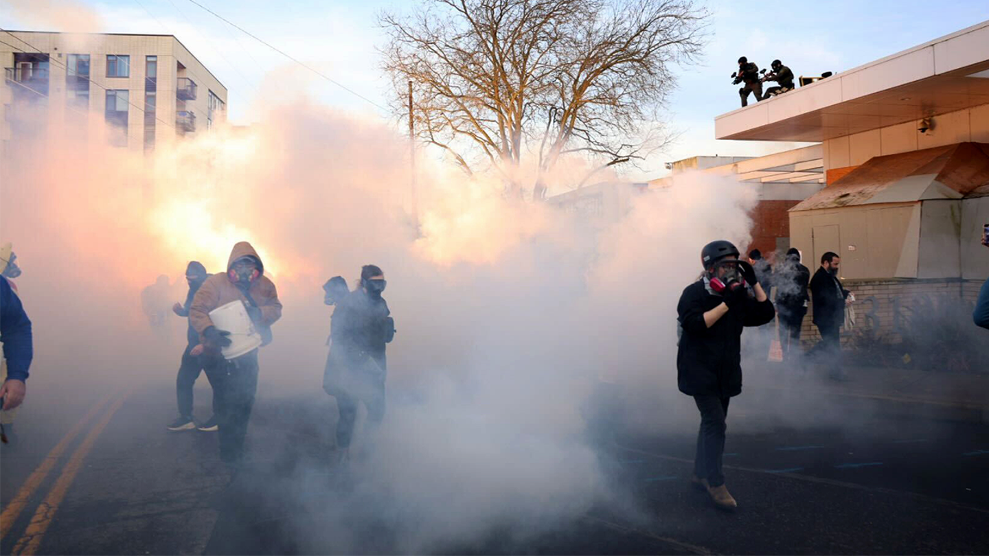Federal agents tossing tear gas at protesters in front of ICE building in Portland, Oregon