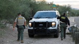 Pima County Sheriff's deputies near a vehicle on the side of the road where they were searching a culvert area less than a mile from Nancy Guthrie's home