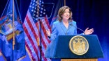Kathy Hochul stands on a stage addressing an audience inside a theater.