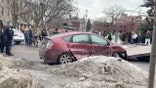 Crowd and police around a car that has been in a car accident.