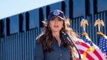 DHS Sec. Kristi Noem speaking in front of the border wall.