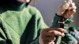 woman holding dropper of extract