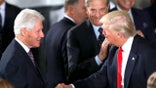 Presidents Clinton and Trump shake hands