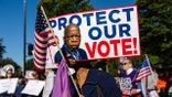 Demonstrators holding signs and gathered on the sidewalk outside the U.S. Supreme Court building.
