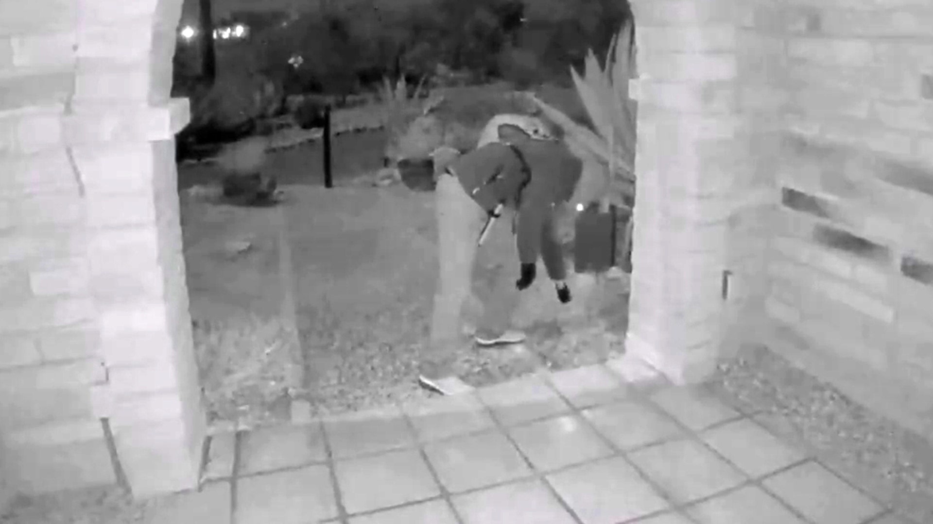 A view from a doorbell camera showing an armed individual outside the residence of Nancy Guthrie in Tucson, Arizona