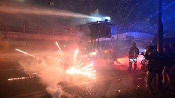 Fireworks fly as hooded protesters clash with police after Olympics open in Milan