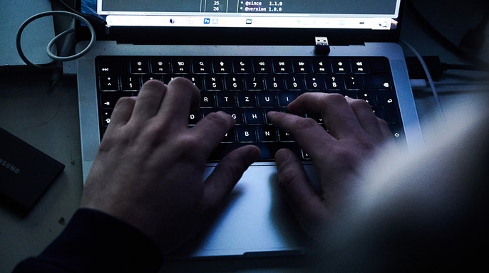 Person typing code on their laptop.
