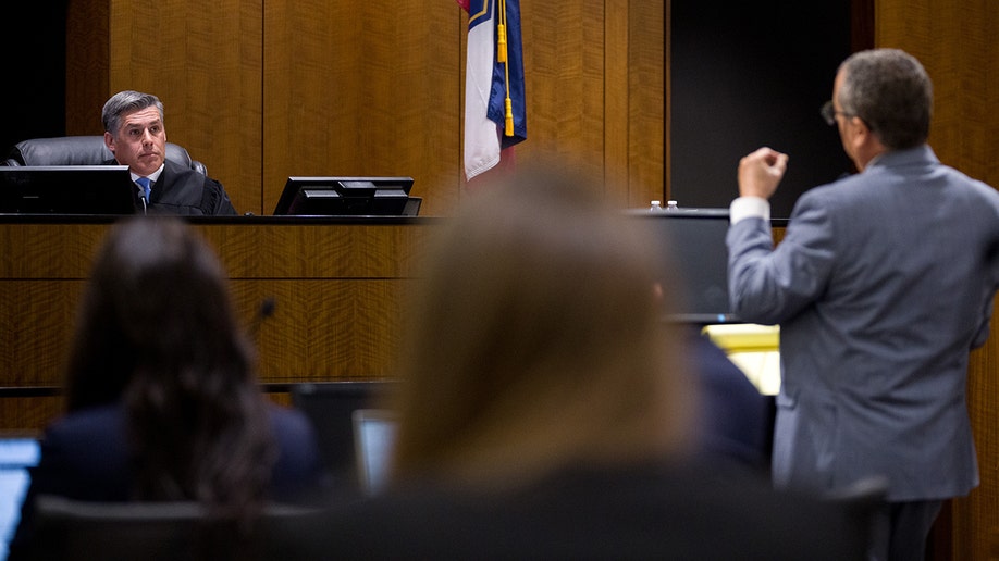 Judge Tony Graf listening to defense attorney Richard Novak in a courtroom.