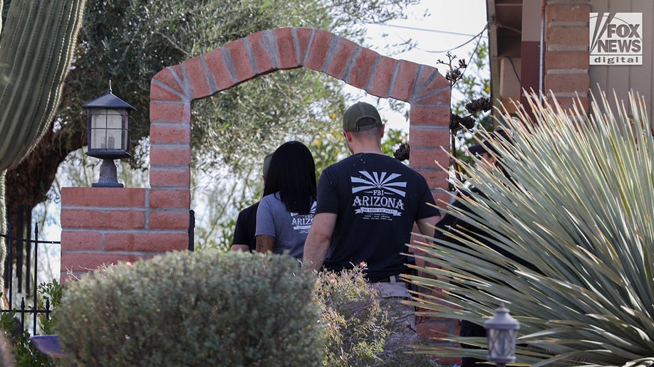 FBI investigators wearing tactical vests walking through Annie Guthrie's neighborhood in Tucson, Arizona