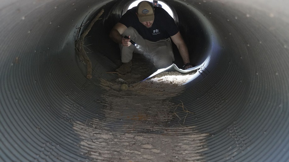 Investigators walking past houses and through a neighborhood in search of Nancy Guthrie