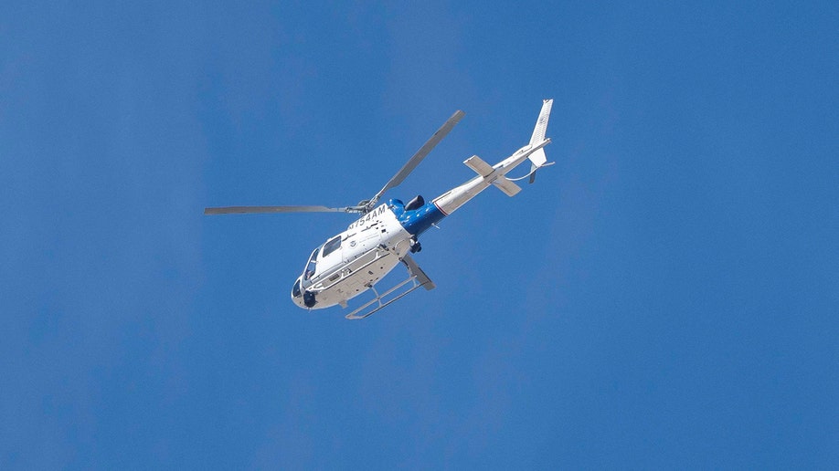 A U.S. Customs and Border Protection helicopter flying over Nancy Guthrie's home.