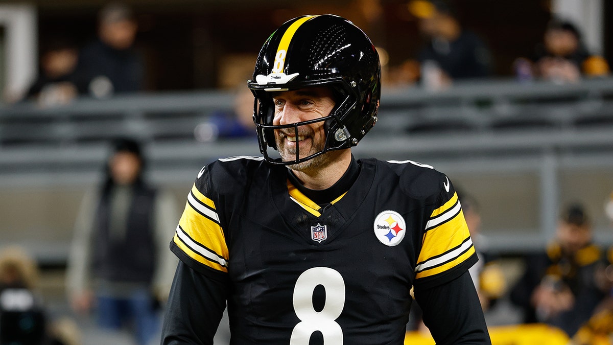 Aaron Rodgers smiles on field