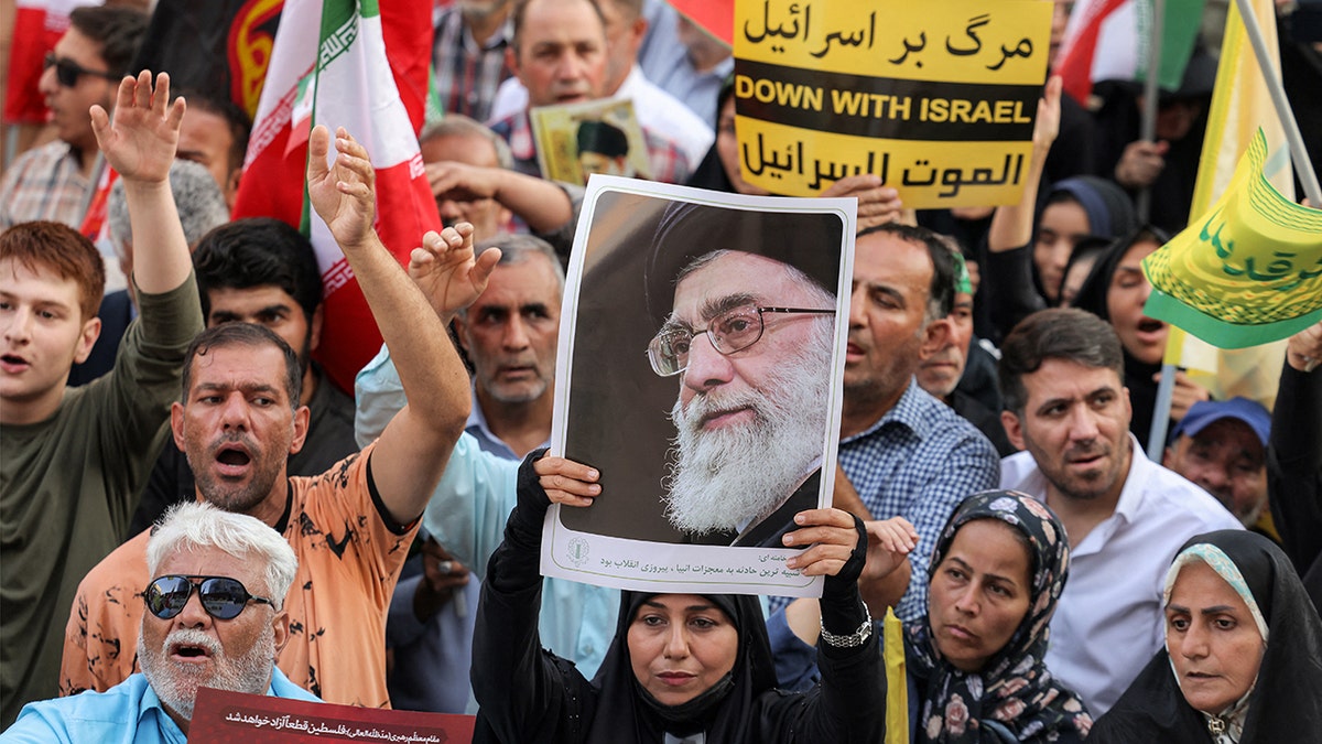 Um manifestante segurando uma foto do aiatolá Ali Khamenei durante um comício em Teerã