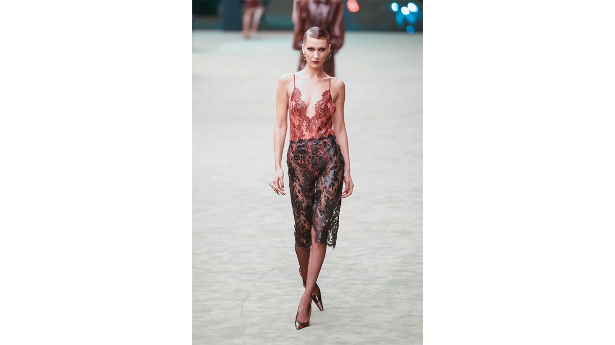 Bella Hadid walking on a runway during a fashion show.