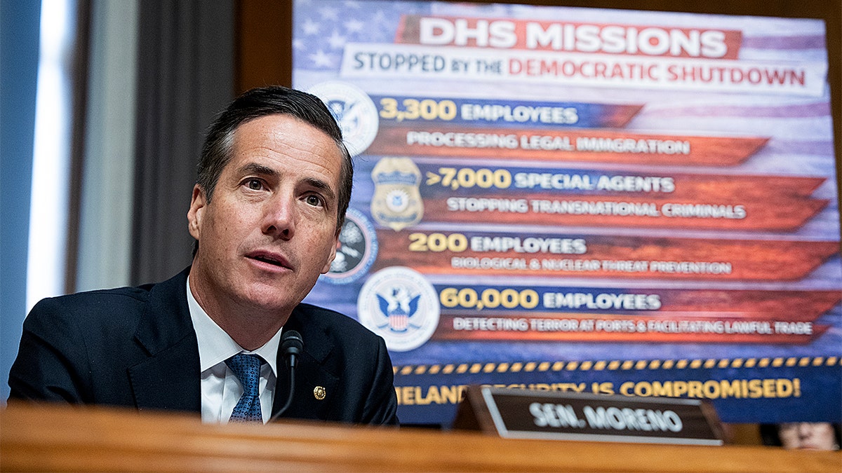 Bernie Moreno referencing a government shutdown sign while questioning Markwayne Mullin during a hearing.