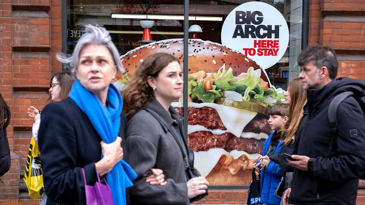 People walking past Big Arch ad