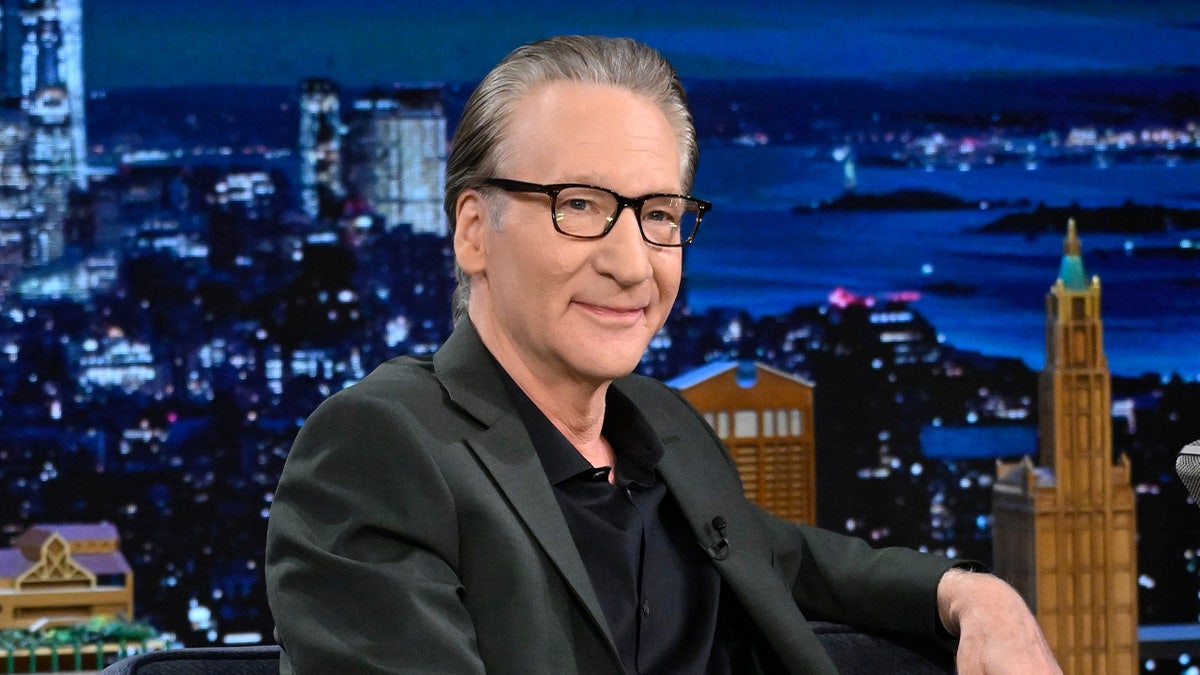 Bill Maher seated on the set of "The Tonight Show."