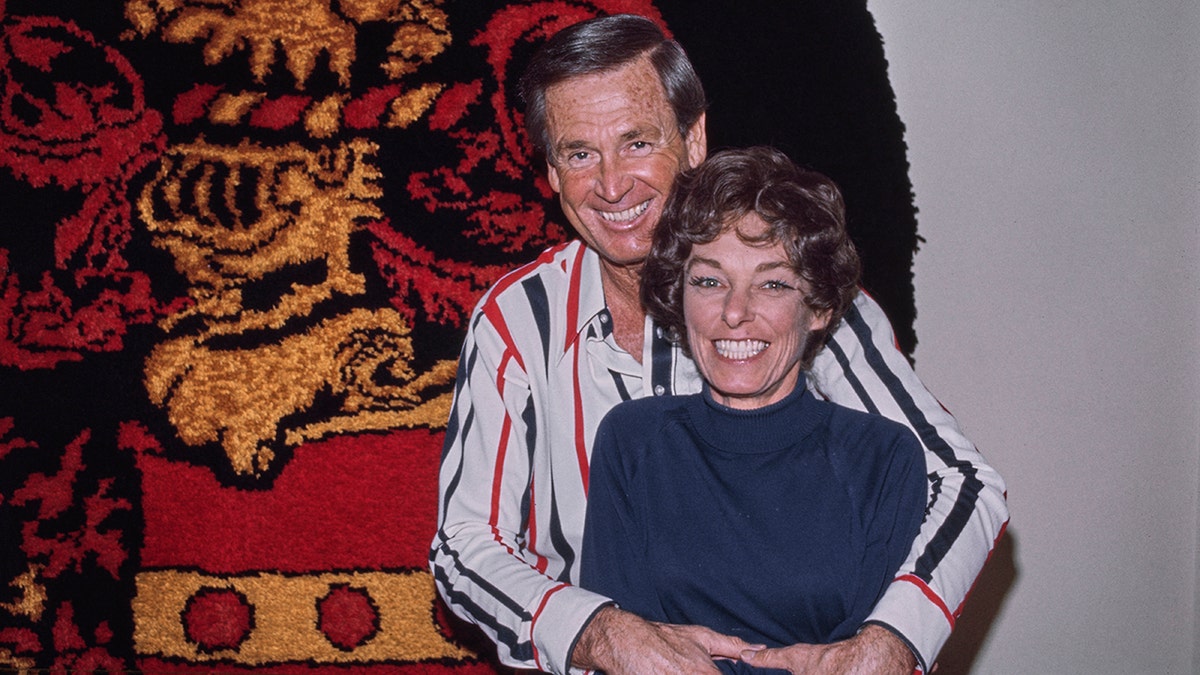 Bob Barker embracing his wife and smiling.