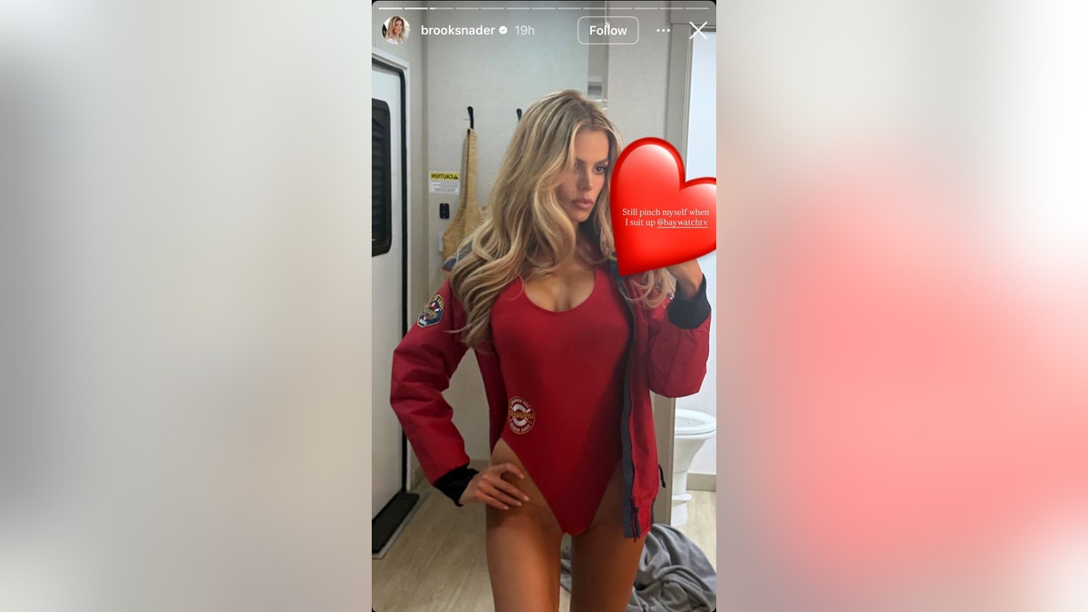 Brooks Nader poses in iconic red "Baywatch" bathing suit