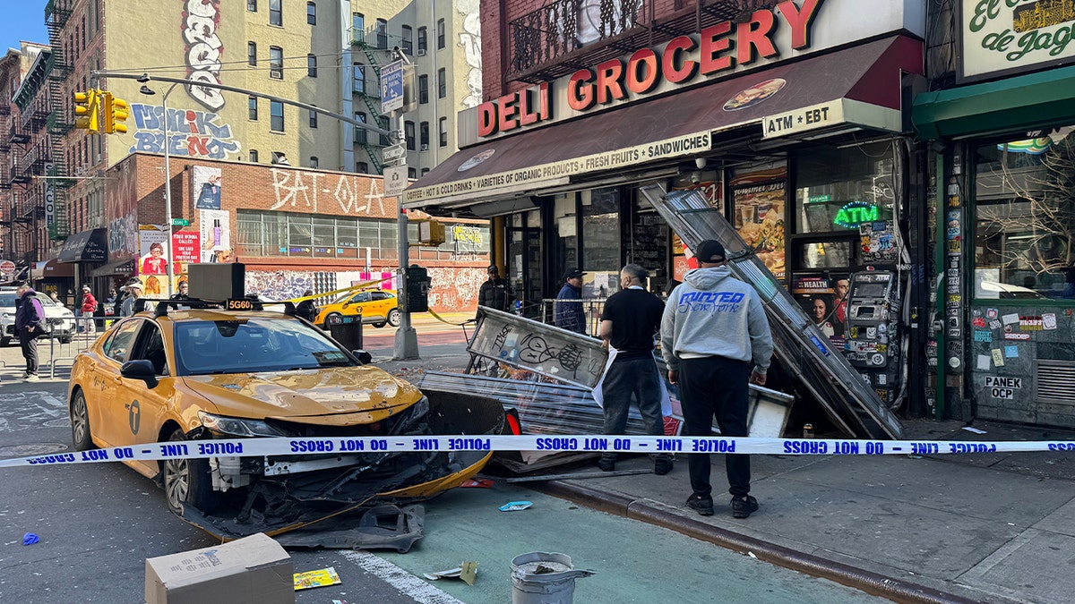 Police portion surrounds crashed NYC taxi extracurricular deli grocery.